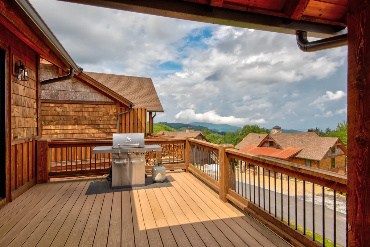 A deck view highlighting a built-in grill set against a backdrop of mountain scenery and deck railings. The image evokes casual cookouts and outdoor leisure in a pet-safe environment.
